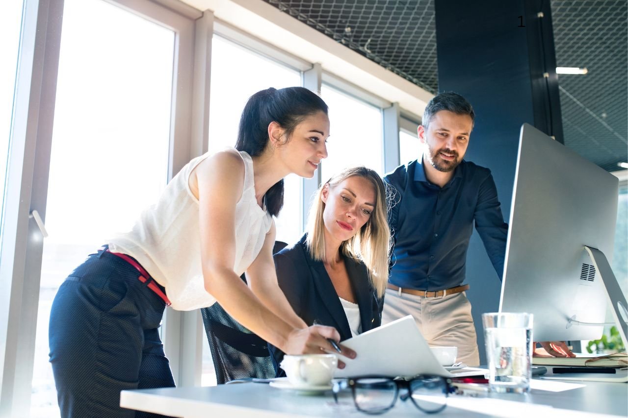 Team collaborating on a project review at an office desk, reflecting Mudita Technicals’ approach of doing the work so clients can focus on what matters.